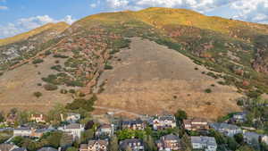 Aerial view of property and surrounding area featuring mountains and nearby suburban area