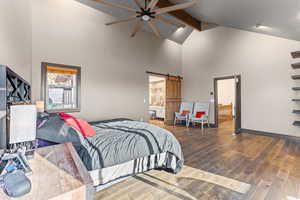 Maste BedroomBedroom featuring hardwood / wood-style flooring, a barn door, beam ceiling, high vaulted ceiling, and ceiling fan