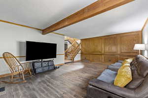 Living room featuring beam ceiling, stairway, dark wood finished floors, a textured ceiling, and ornamental molding