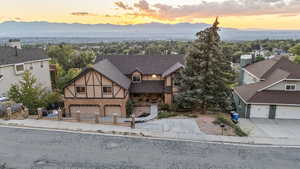 View of front facade featuring driveway, a mountain view, a residential view, and roof with shingles