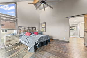 Master Bedroom featuring a barn door, high vaulted ceiling, dark wood-style flooring, and ceiling fan. Beautiful deck to enjoy an amazing view of the City