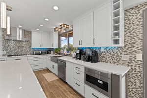 Kitchen with white cabinetry, light stone countertops, open shelves, pendant lighting, and recessed lighting