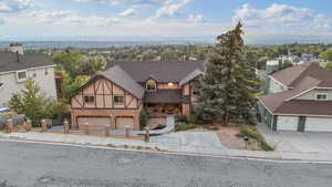 View of front of home featuring a shingled roof, concrete driveway, a residential view, and an attached garage