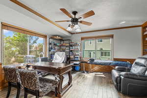 Office space featuring crown molding, wood-type flooring, a textured ceiling, and ceiling fan