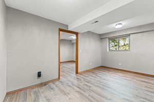 Unfurnished room featuring light wood-type flooring and baseboards