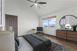 Bedroom featuring dark wood-style flooring, high vaulted ceiling, and ceiling fan