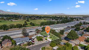 Aerial view of residential area with a mountain backdrop and property parcel outlined