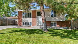 View of front of house featuring brick siding, a carport, and driveway