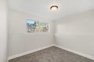 Carpeted empty room featuring baseboards