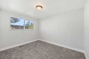 Carpeted spare room featuring baseboards and a textured ceiling