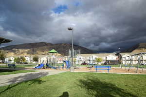 Community jungle gym with a mountain view, a lawn, and a residential view