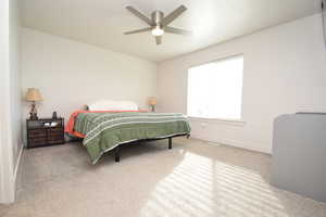 Bedroom featuring light colored carpet and a ceiling fan