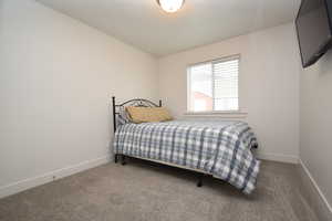 Carpeted bedroom featuring baseboards