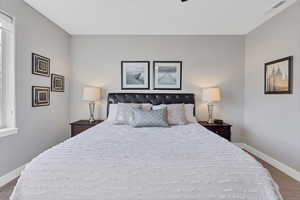 Bedroom with dark wood finished floors and ceiling fan