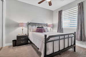 Carpeted bedroom featuring baseboards and a ceiling fan