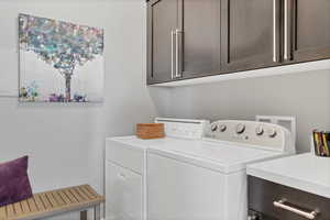 Washroom featuring cabinet space and separate washer and dryer