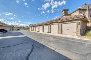 View of asphalt road with community garages