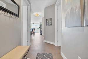 Hall with baseboards and a textured ceiling
