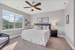Bedroom featuring carpet flooring, a ceiling fan, and a mountain view