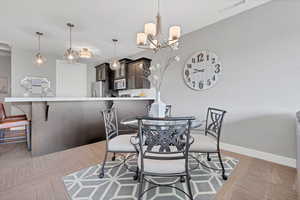 Dining area featuring a chandelier and light carpet