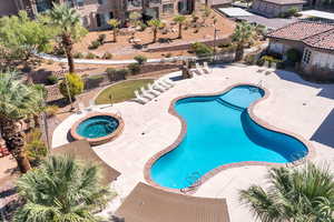 Community pool with a patio area, a community hot tub, and a fenced backyard