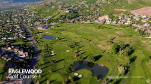 Aerial overview of property's location with nearby suburban area, a golf course, and a large body of water
