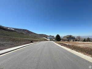 View of asphalt street featuring curbs and a mountain view