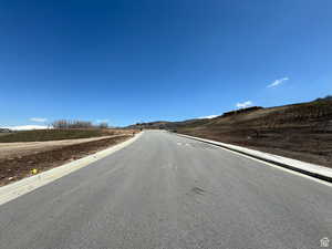 View of asphalt street featuring curbs