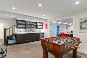 Game room with a bar, light colored carpet, recessed lighting, and wine cooler