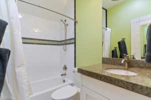 Full bathroom featuring shower / bath combo with shower curtain and vanity