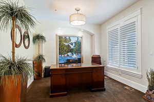 Office space with dark carpet and baseboards