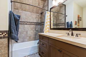 Bathroom with shower / bathtub combination with curtain and vanity