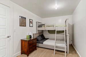 Bedroom with light colored carpet and baseboards