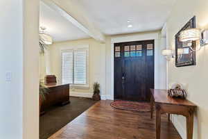Entrance foyer with beamed ceiling, dark wood-style floors, and recessed lighting