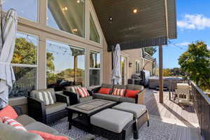 Wooden terrace featuring a hot tub and an outdoor living space