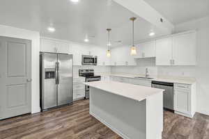 Kitchen featuring stainless steel appliances, white cabinets, recessed lighting, a center island, and pendant lighting