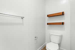 Bathroom with toilet and baseboards
