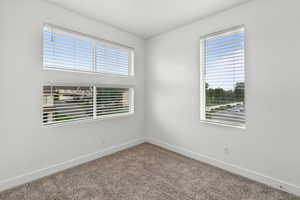 Carpeted empty room with baseboards
