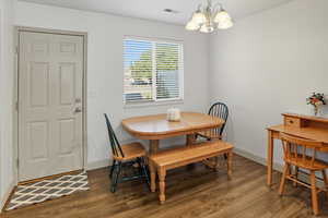 Dining area with wood finished floors and a chandelier
