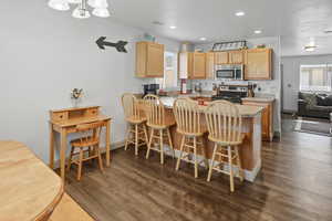 Kitchen featuring a breakfast bar, stainless steel appliances, and LVP Floorin