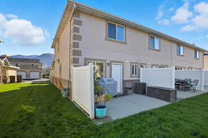 Back of house featuring a mountain view, a patio and grilling area