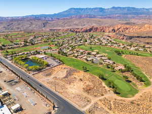 View of property location with a water and mountain view, a local golf course, and nearby suburban area