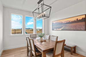 Dining space featuring light wood-style floors, a chandelier, and a mountain view