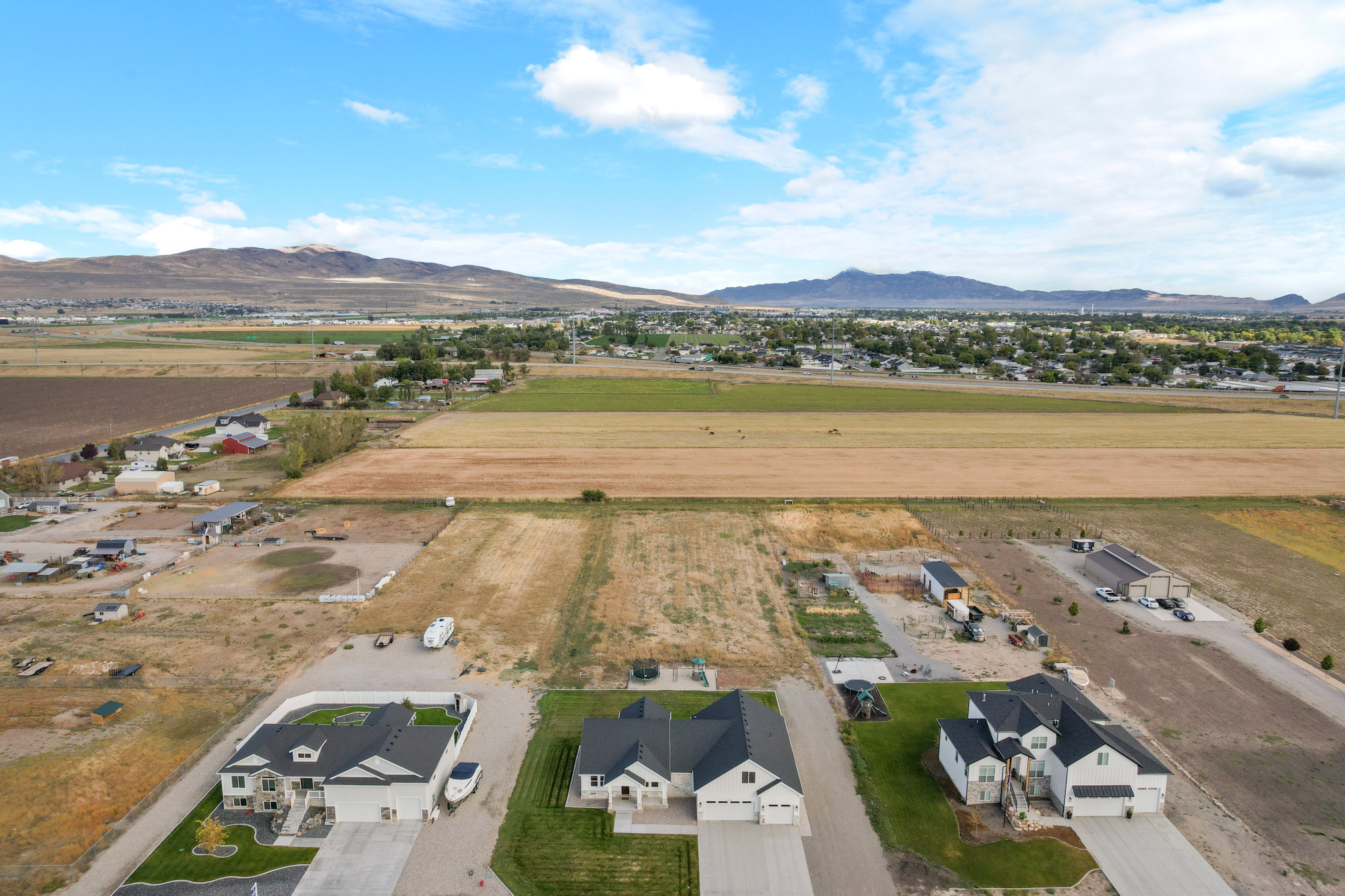 Aerial view of property and surrounding area featuring a mountainous background and rural landscape