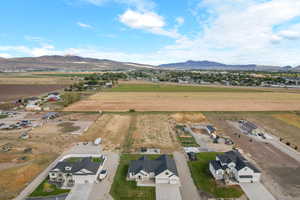 Aerial view of property and surrounding area featuring a mountainous background and rural landscape