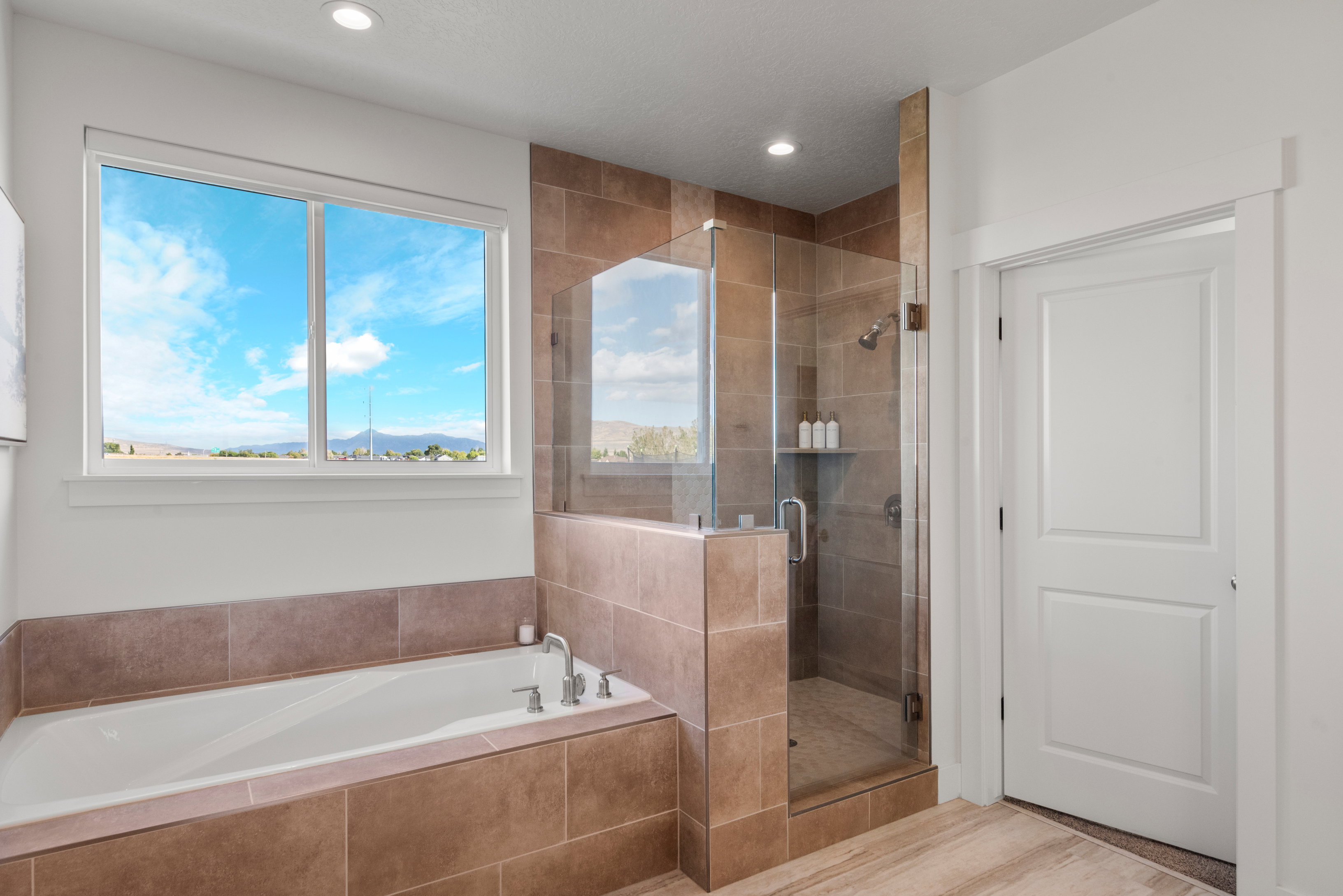 Bathroom with a stall shower, a garden tub, a mountain view, recessed lighting, and wood finished floors