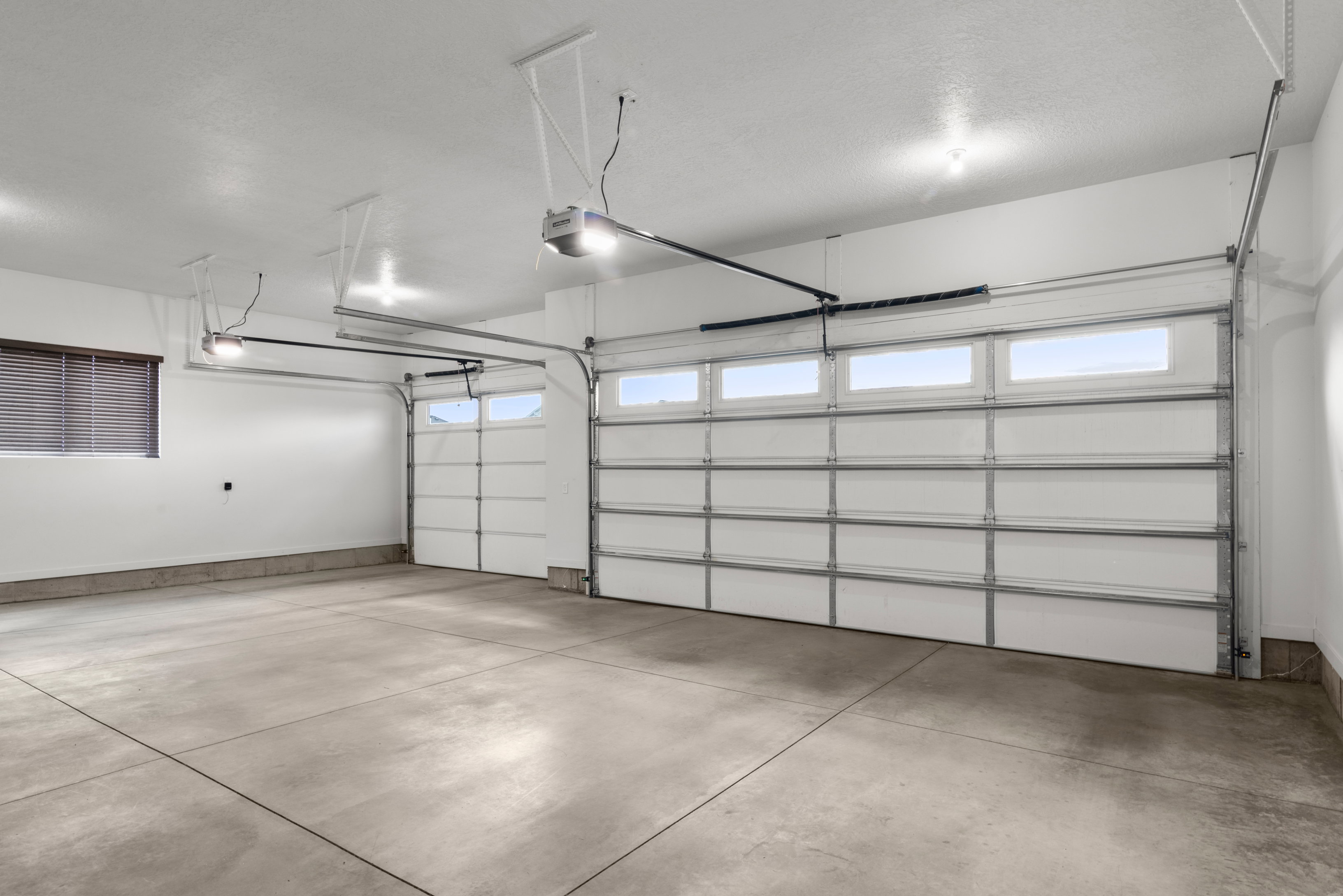 Garage featuring a garage door opener and baseboards
