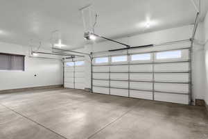 Garage featuring a garage door opener and baseboards