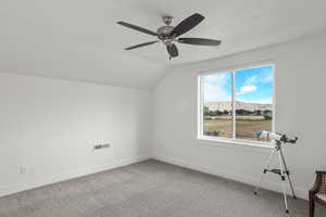 Additional living space with a mountain view, carpet flooring, lofted ceiling, a ceiling fan, and a textured ceiling