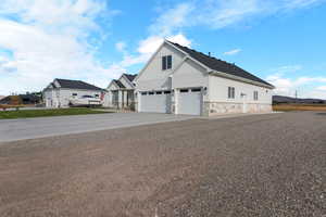 View of property exterior with board and batten siding, concrete driveway, stone siding, and an attached garage